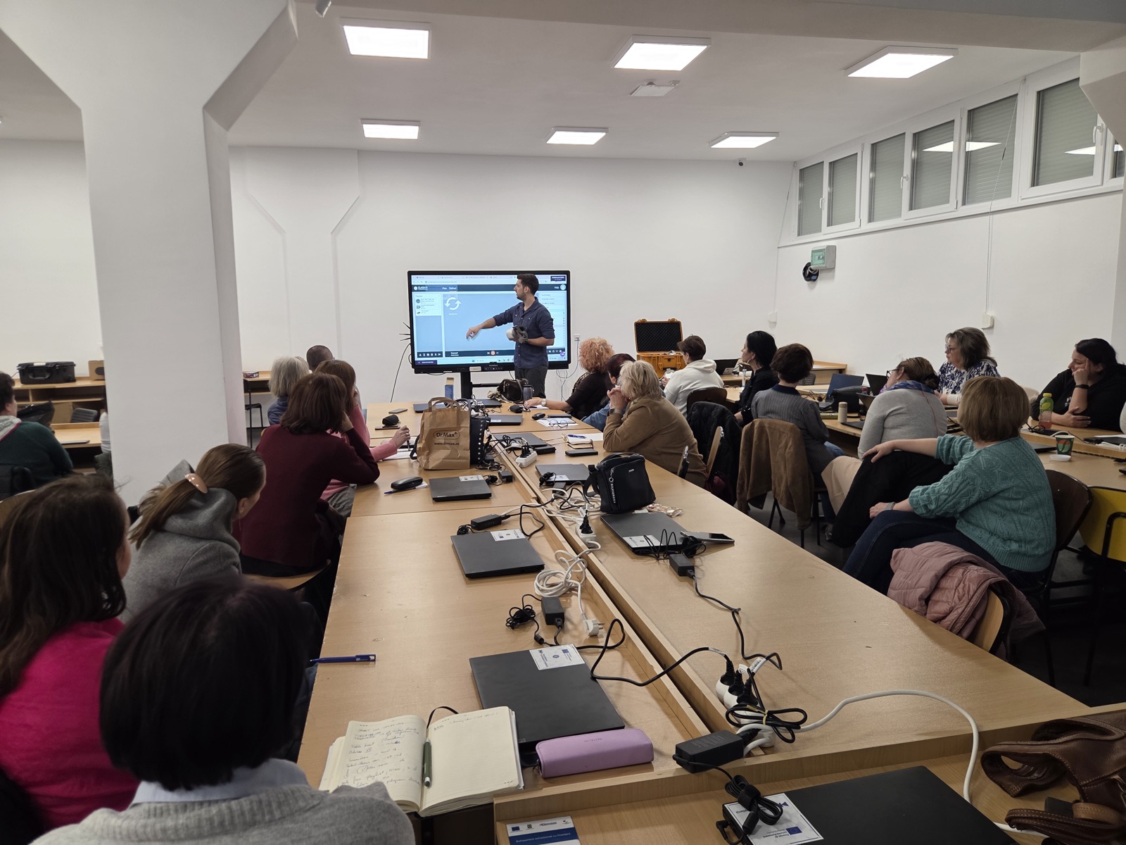 Formator explicând software-ul educațional pe display interactiv